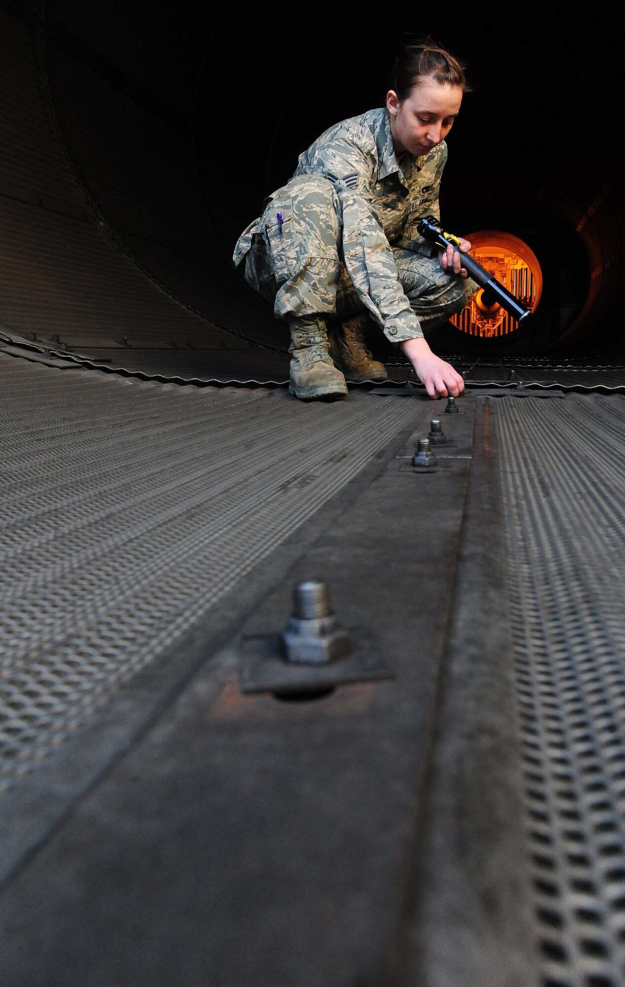 WHITEMAN AIR FORCE BASE, Mo. -- Senior Airman Kaitlyn Fawber, 509th Maintenance Squadron aerospace propulsion journeyman, inspects a test cell rivet, Feb. 13. The test cell is a $2.9-million-facility used by jet engine mechanics to test the serviceability of jet engines. (U.S. Air Force photo/Staff Sgt. Nick Wilson) (Released)