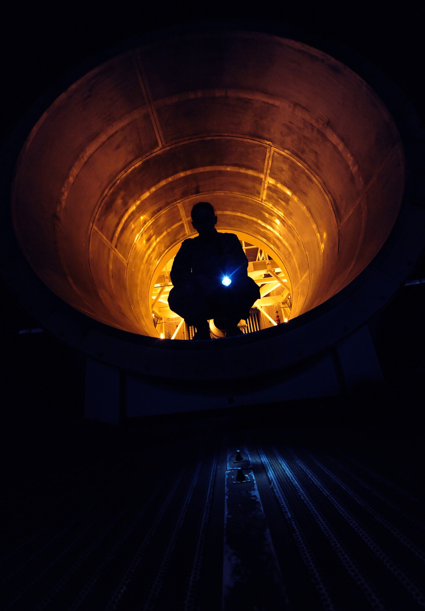WHITEMAN AIR FORCE BASE, Mo. -- Senior Airman Kaitlyn Fawber, 509th Maintenance Squadron aerospace propulsion journeyman, shines a flash light on a test cell exhaust tube rivet, Feb. 13. The rivet maintains the sound-proofing in the cell. (U.S. Air Force photo/Staff Sgt. Nick Wilson) (Released)