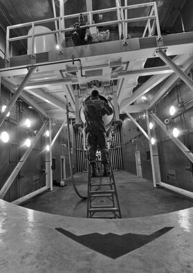 WHITEMAN AIR FORCE BASE, Mo. -- Senior Airman Kaitlyn Fawber, 509th Maintenance Squadron aerospace propulsion journeyman, points out instructions to Airman 1st Class Lester Popham, 509th MXS aerospace propulsion apprentice, as he inspects the exhaust of a B-2 Spirit engine for foreign object debris and oil in the test cell, Feb. 13. The test cell is used by aerospace propulsion mechanics to test the serviceability of jet engines before they are installed in the B-2 for flight. (U.S. Air Force photo/Staff Sgt. Nick Wilson) (Released)
