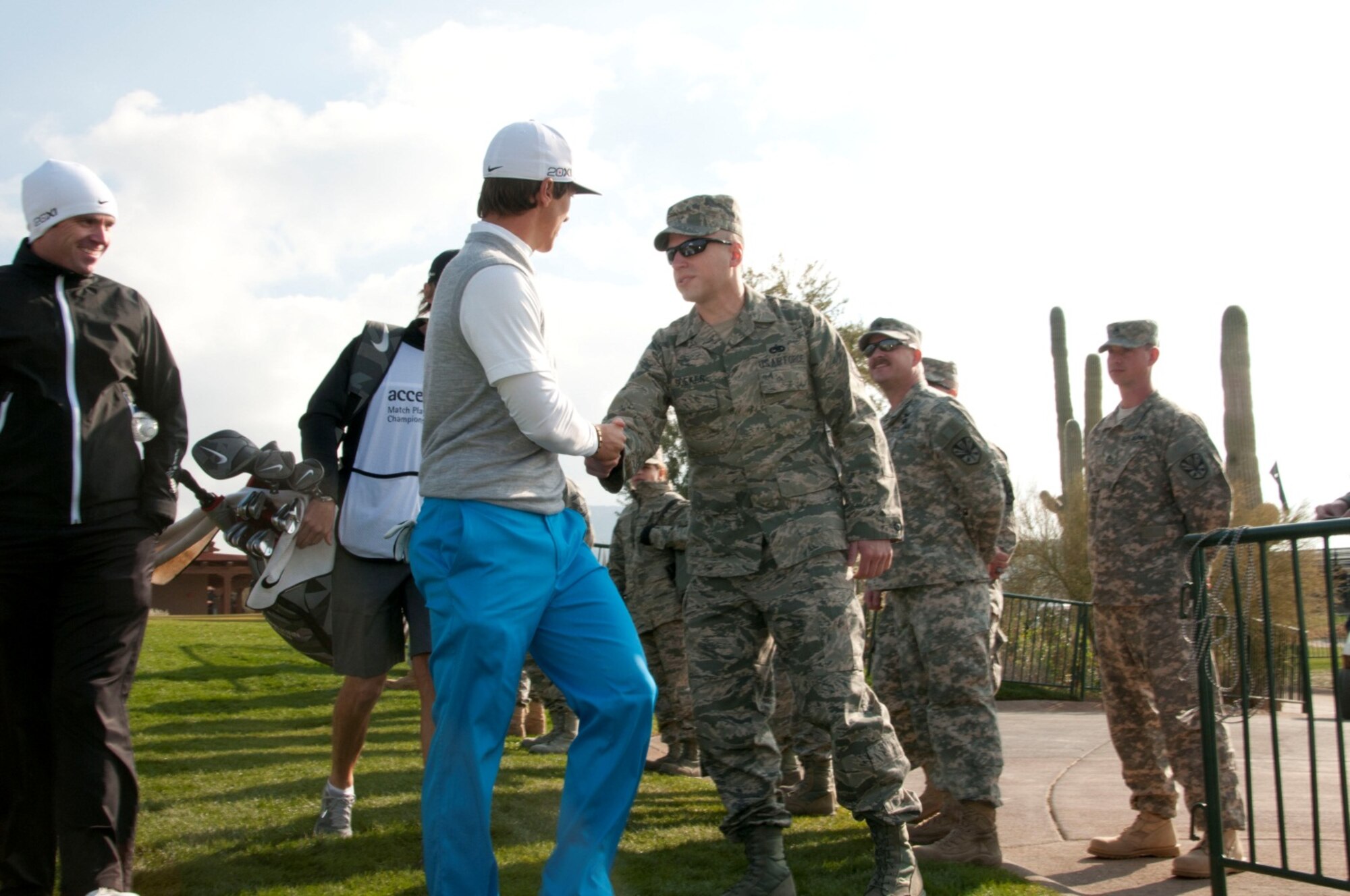 U.S. Air Force Staff Sgt. Ty Goeken, an Airman with the 162nd Fighter Wing, greets PGA Tour Thorbjorn Olesen as he makes his way to the first tee of the day at the Accenture Match Play Championship, held at the Golf Club at Dove Mountain in Marana, Ariz., Feb. 22.  Air and Army National Guardsmen from the 162nd Fighter Wing and the 285th Attack Reconnaissance Battalion in Tucson, Ariz. lined the walkway to the first hole to greet golfers before the beginning of play. (U.S. Air Force photo by Tech. Sgt. Hollie A. Hansen/Released)