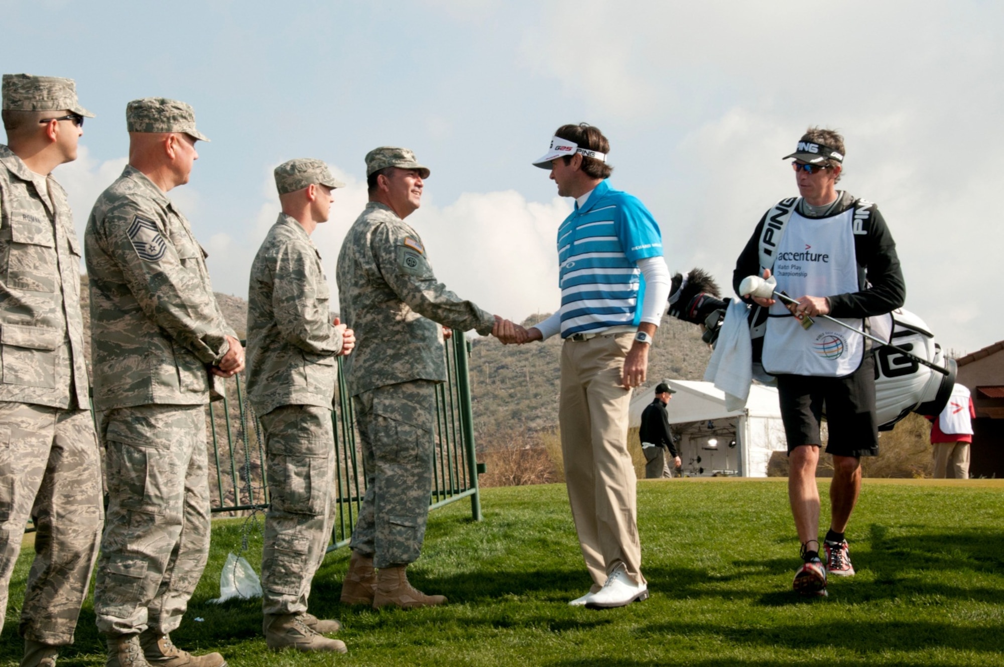 U.S. Army 1st Sgt. William Aragon, a soldier with the 285th Attack Reconnaissance Battalion, ‘coins’ PGA Tour golfer Bubba Watson as he makes his way to the first tee of the day at the Accenture Match Play Championship, held at the Golf Club at Dove Mountain in Marana, Ariz., Feb. 22.  Air and Army National Guardsmen from the 162nd Fighter Wing and the 285th Attack Reconnaissance Battalion in Tucson, Ariz. lined the walkway to the first hole to greet golfers before the beginning of play. (U.S. Air Force photo by Tech. Sgt. Hollie A. Hansen/Released)