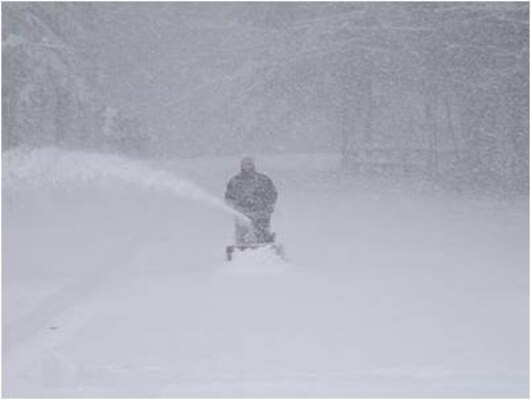 A Corps maintenance worker clears snow at a lake project.