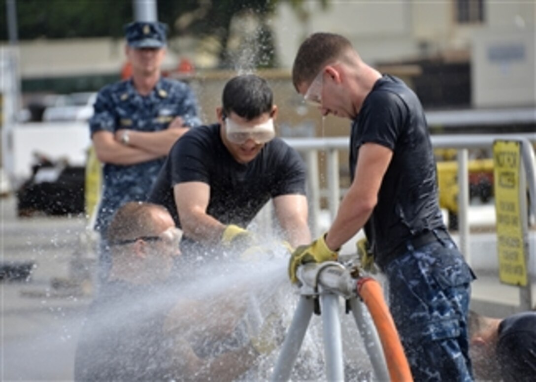 U.S. Navy Seaman David Lloyd, right, Petty Officer 3rd Class Trent Tyykila, center, and Petty Officer 2nd Class Colby Kraght patch a simulated damaged pipe during a damage control contest between the crews of the submarines USS Texas (SSN 775) and the USS City of Corpus Christi (SSN 705) at Joint Base Pearl Harbor-Hickam, Hawaii, on Feb. 21, 2013.  