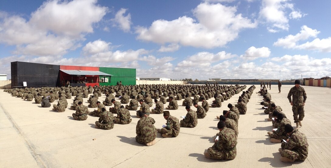 Soldiers as part of the Afghanistan National Army's 8th Corps, 199th Recruit Battalion, made up of approximately 600 personnel, take their placement exams at the Regional Military Training Center. In a manner similar to how the U.S. military tests an applicant's aptitude to place their skill sets with a military occupational specialty; the Afghan Army administers a similar test to assess a soldier's ability to function in certain jobs.  Pictured above, one of the RMTC battalion commanders monitors soldiers taking the test to prevent cheating.