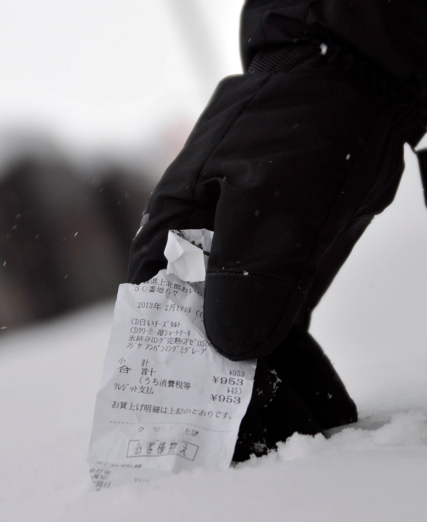 U.S. Air Force Senior Airman Cory Crim, 35th Maintenance Squadron Precision Measurement Lab technician, pulls a receipt from the snow during a citywide cleanup event in Misawa City, Japan, Feb. 23, 2013. Service members from the U.S. Air Force and the Navy along with family members took part in the second Misawa City Cleanup event. The event was created to help beautify the off-base community and reinforce host nation partnerships. (U.S. Air Force photo by Tech. Sgt. Phillip Butterfield)