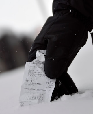 U.S. Air Force Senior Airman Cory Crim, 35th Maintenance Squadron Precision Measurement Lab technician, pulls a receipt from the snow during a citywide cleanup event in Misawa City, Japan, Feb. 23, 2013. Service members from the U.S. Air Force and the Navy along with family members took part in the second Misawa City Cleanup event. The event was created to help beautify the off-base community and reinforce host nation partnerships. (U.S. Air Force photo by Tech. Sgt. Phillip Butterfield)