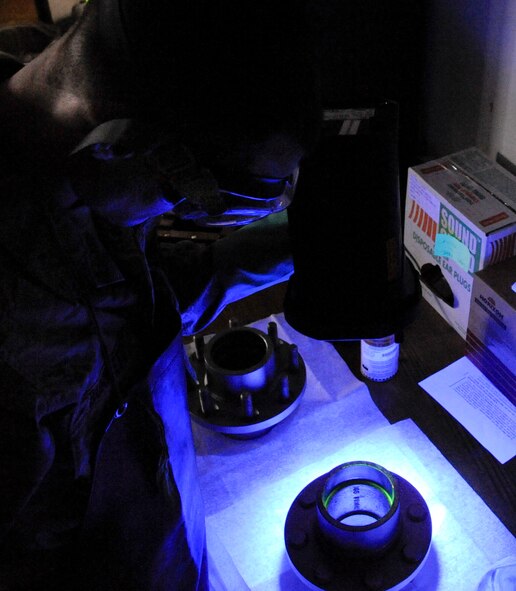 Senior Airman Brian Burkett, 2nd Maintenance Squadron Non-Destructive Inspection, observes a front hub under an ultraviolet light during a magnetic particle inspection on Barksdale Air Force Base, La., Feb. 26. The NDI section assists 2 MXS by helping pinpoint damage to aircraft parts by using ultrasound and X-rays to find damage not visible to the naked eye. (U.S. Air Force photo/Airman 1st Class Andrew Moua)