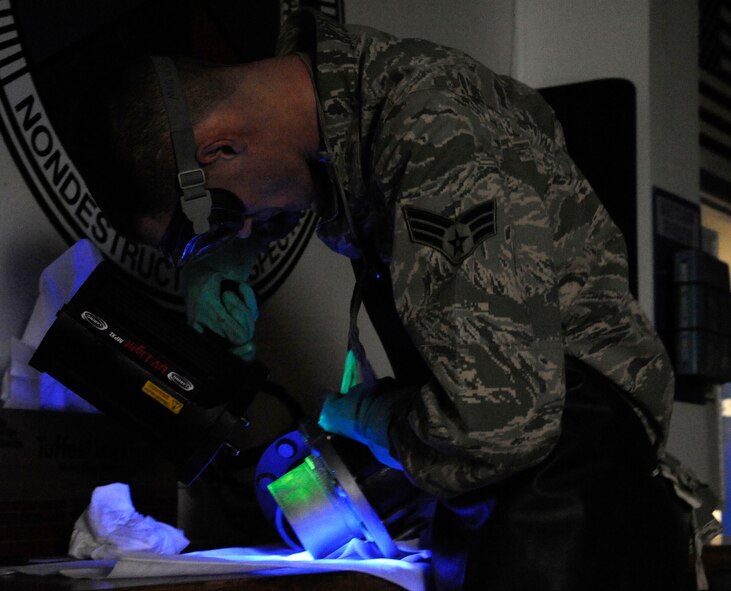 Senior Airman Brian Burkett, 2nd Maintenance Squadron Non-Destructive Inspection, looks for magnetic particles under an ultraviolet light on Barksdale Air Force Base, La., Feb. 26. A variety of parts come into NDI, from aircraft parts to standard vehicle components. The particles fill in any cracks, and make them easier to identify before parts are repaired.   (U.S. Air Force photo/Airman 1st Class Andrew Moua)