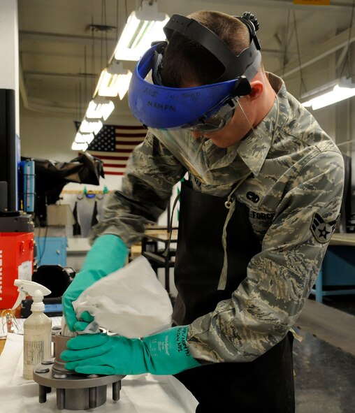 Senior Airman Brian Burkett, 2nd Maintenance Squadron Non-Destructive Inspection, wipes down front hubs in preparation for a magnetic particle inspection on Barksdale Air Force Base, La., Feb. 26. Parts or components are sprayed with a magnetic particle solution and observed under an ultra-violet light for cracks or damage. (U.S. Air Force photo/Airman 1st Class Andrew Moua)