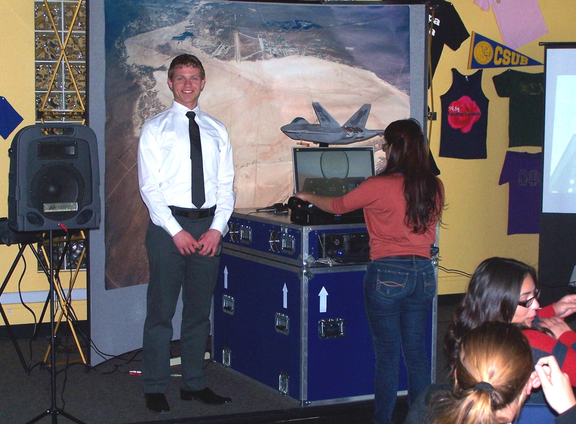 Derek Lennon, 412th Test Engineering Group, poses for a picture as a young student flies an F-22 Raptor with a portable simulator.  Engineers from the 412th Test Wing visited California State University, Bakersfield Feb. 22 as part of the 13th Annual Engineers Day event, which offered high schoolers from Kern County the chance to learn more about what engineers and geoligists do.  The event was sponsored by CSUB, The Society of Petroleum Engineers and Kern County Superintendent of Schools School to Career.  (Courtesy photo)