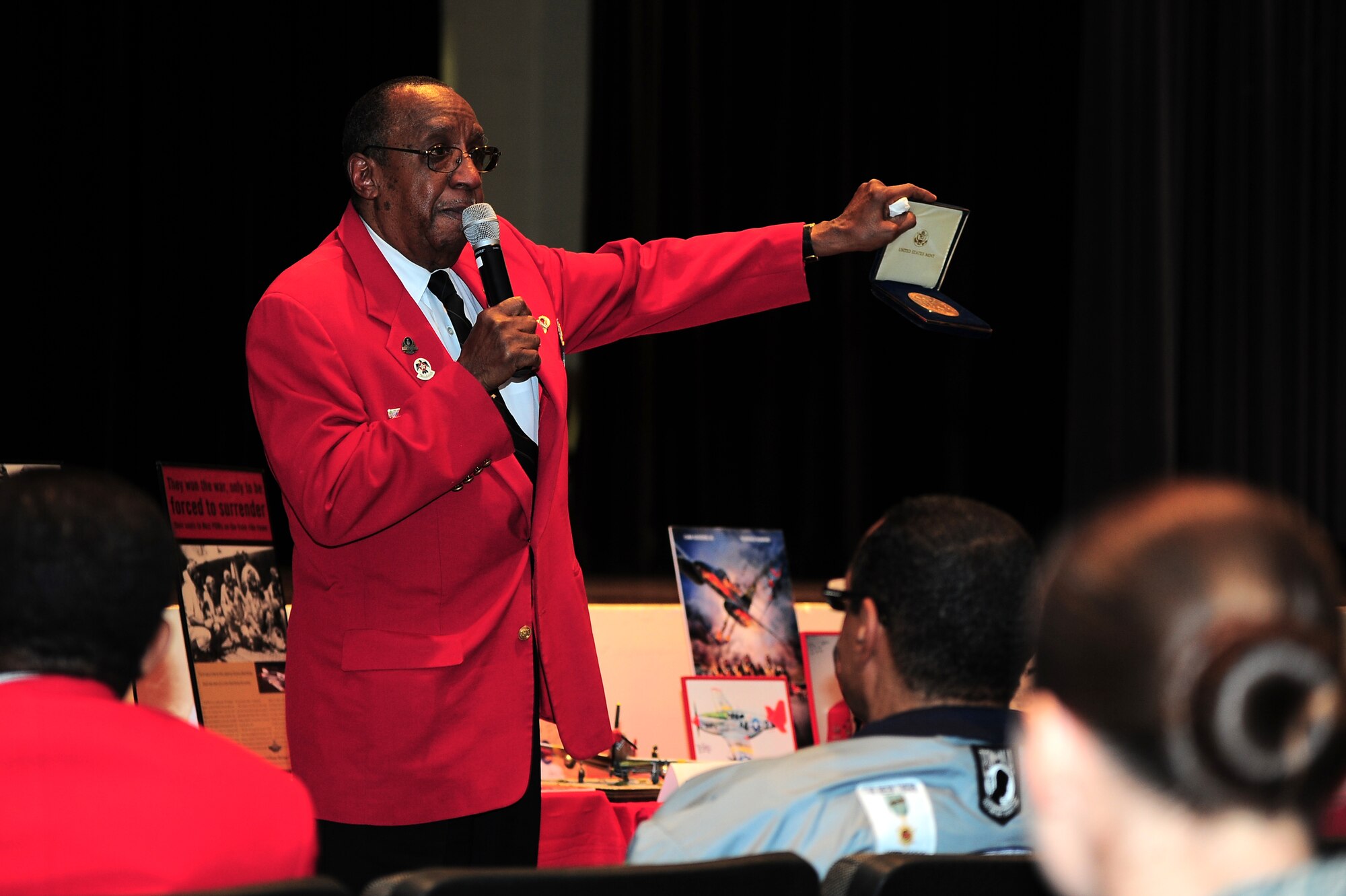 Leonard Hunter, member of the local Chapter of the Tuskegee Airman Inc., shows the crowd a Congressional Gold Medal during the Leadership Lecture Series: Perseverance through Adversity on Seymour Johnson Air Force Base, N.C., Feb. 22, 2013. Hunter recalled the story of the Tuskegee Airmen for several members of Team Seymour in attendance. (U.S. Air Force photo/Airman 1st Class Aubrey White/Released)