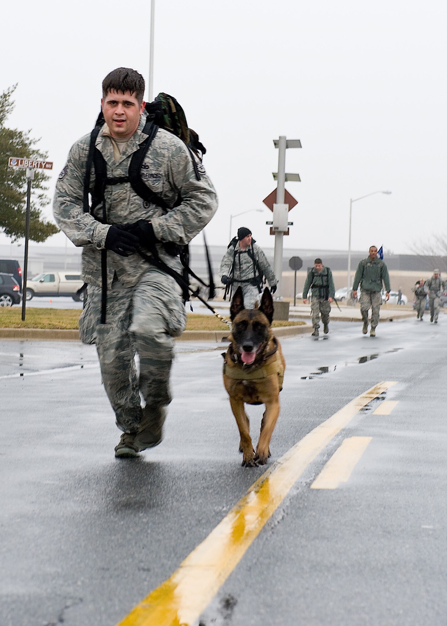 A member of the 436th Security Forces Squadron, and his military working dog, compete in the 14th Annual Korean War Ruck March Feb. 23, 2013, at Dover Air Force Base, Del. Runners were required to wear 30-pound rucksacks throughout the 6.2-mile course. (U.S. Air Force Photo/Senior Airman Sam Taylor)