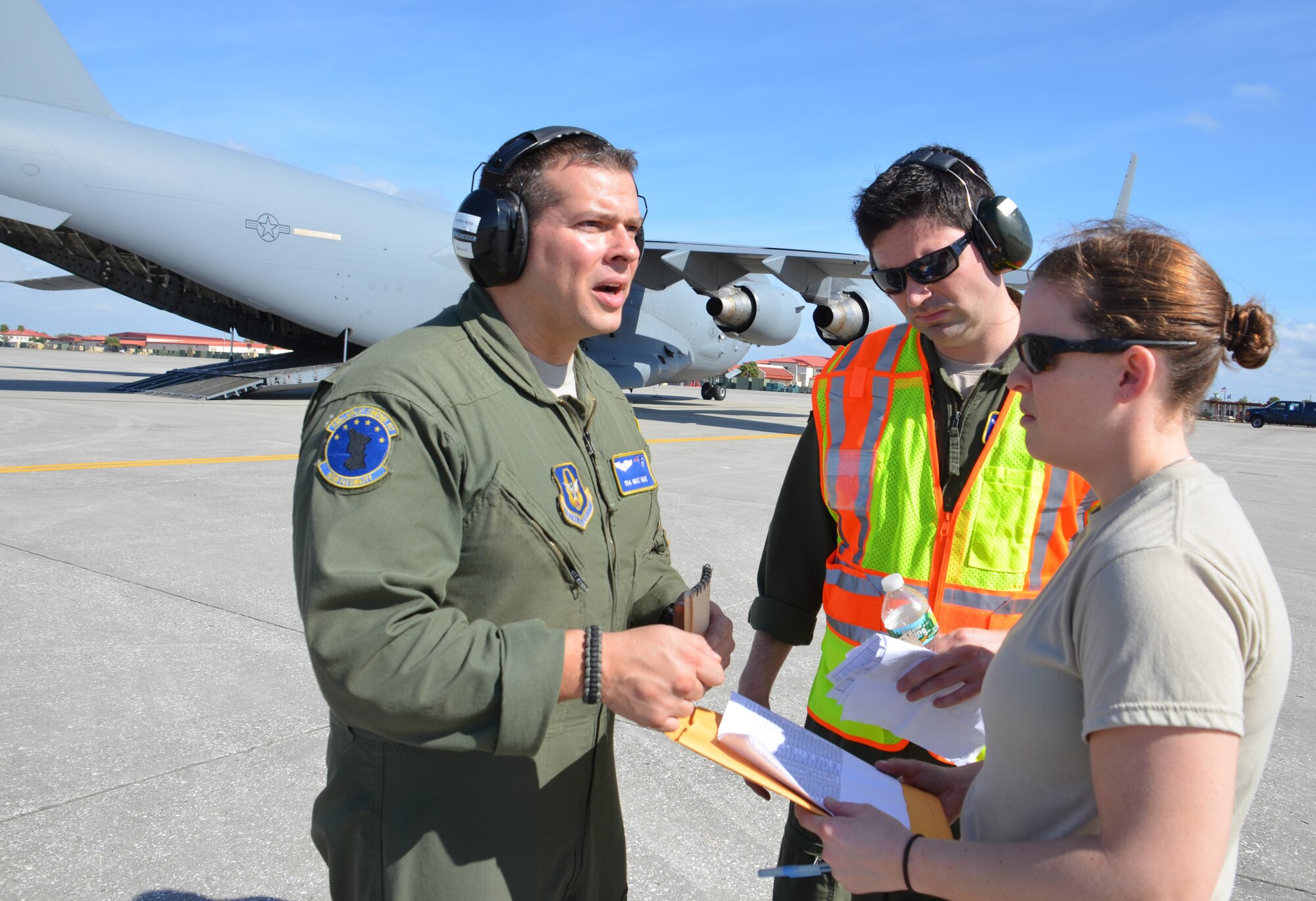 From left, SrA. Mike Muise, SMSgt. Desmond Mullally, and TSgt. Tawny Boulanger discuss airlift operations during the Patriot Sands exercise, Feb. 22. SrA. Muise and SMSgt. Mullally are assigned to the 439th Airlift Control Flight, while TSgt. Boulanger is with the 58th Aerial Port Squadron. (US Air Force photo/MSgt. Andrew Biscoe) 