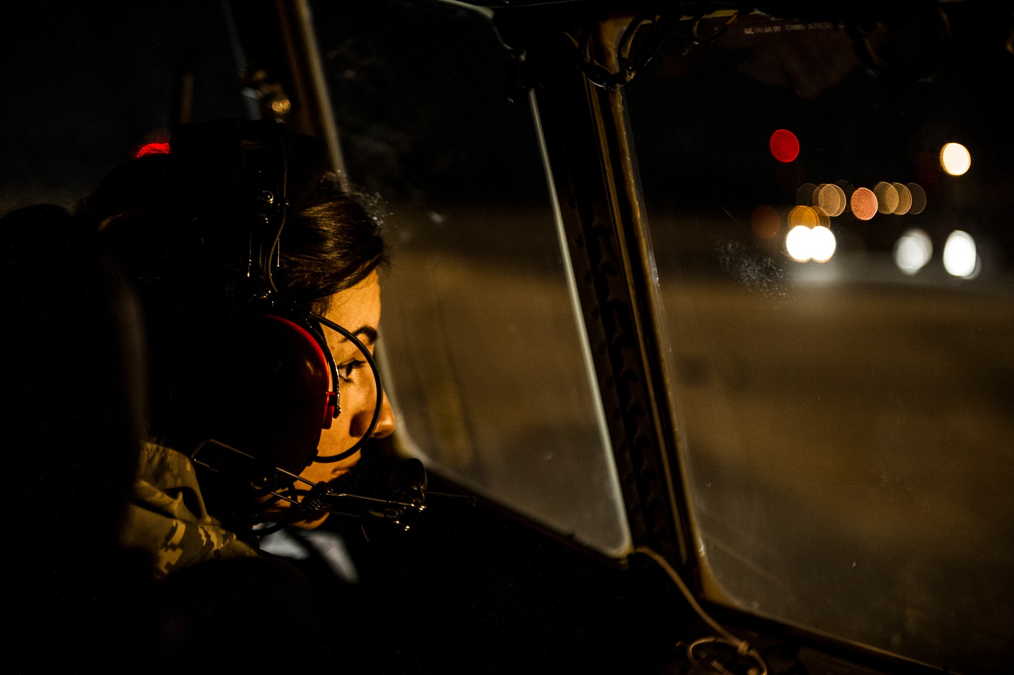 U.S. Air Force Senior Airman Nathalyn Lennon, a crew chief of the 4th Aircraft Maintenance Unit, stares out a cock-pit window of an AC-130U gunship while towing the aircraft to a new location on the flightline at Hurlburt Field, Fla., Feb. 20, 2013. One person has to work the brakes of the aircraft while another uses a vehicle to position the aircraft in its new location. (U.S. Air Force photo/Airman 1st Class Christopher Callaway) 