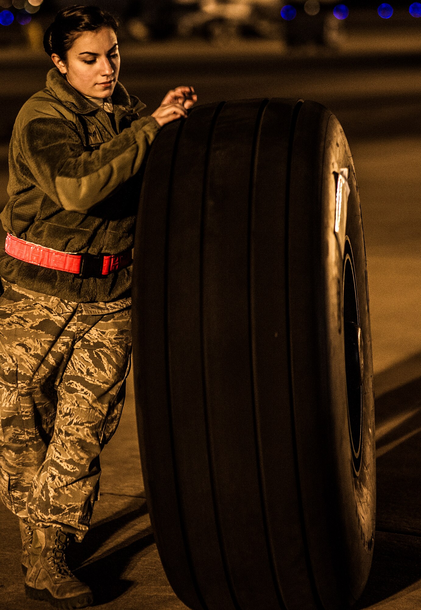 U.S. Air Force Senior Airman Nathalyn Lennon, a crew chief at the 4th Aircraft Maintenance Unit, moves a tire before replacing the brakes of an AC-130U gunship at the flightline on Hurlburt Field, Fla., Feb. 20, 2013. The 4th AMU maintains the AC-130U gunship and supports training and contingency requirements of the 4th and 19th Special Operations Squadrons. (U.S. Air Force photo/Airman 1st Class Christopher Callaway)
