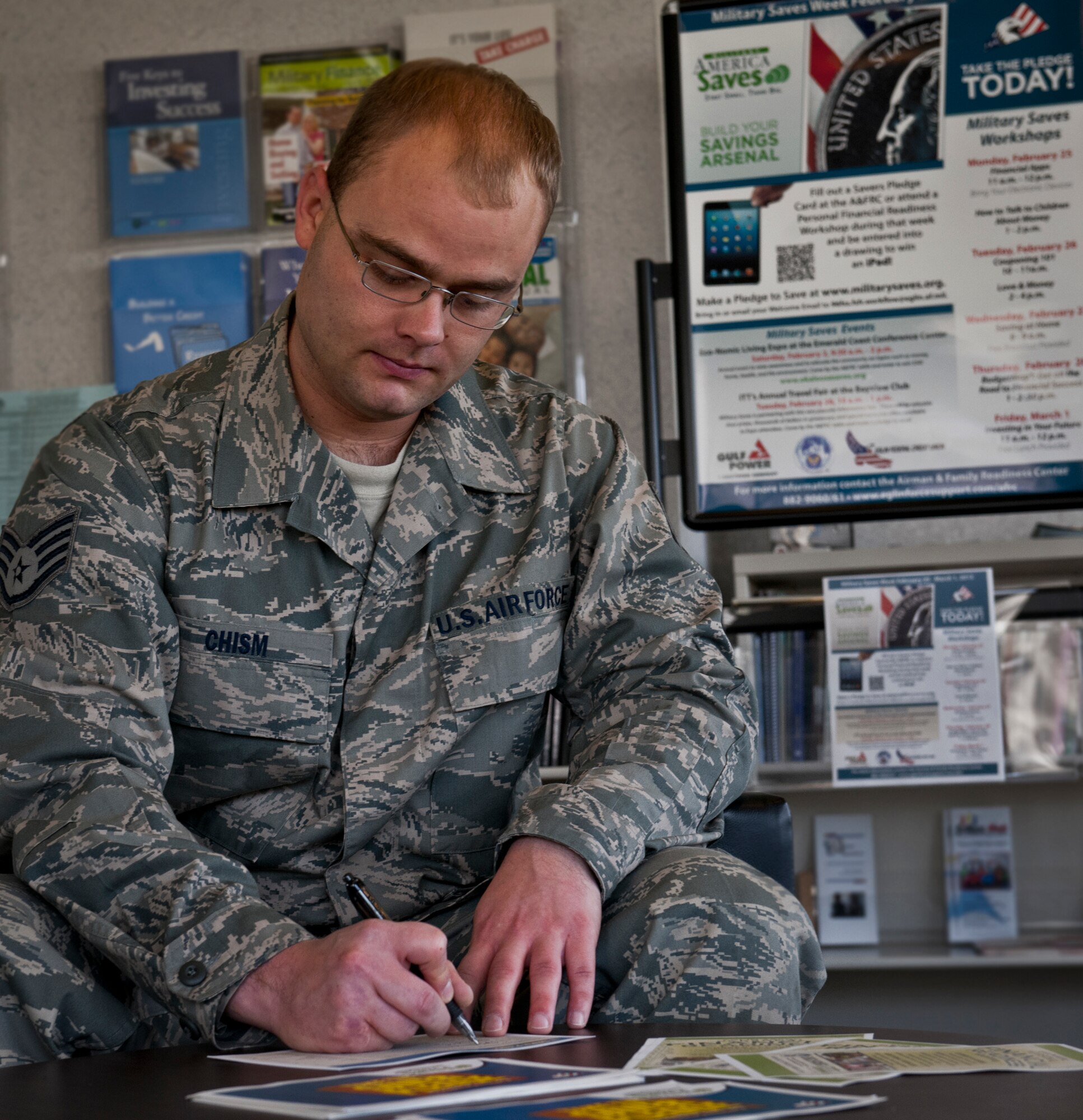 Staff Sgt. Corey Chism, of the 728th Air Control Squadron, signs the “pledge to save” during Military Saves Week at Eglin Air Force Base, Fla., Jan. 26.  Military Saves Week featured workshops geared to help military members and their families save money.  Anyone who pledges during the week is eligible for an IPad drawing Feb. 4.  For more information on the pledge, go to www.militarysaves.org.  (U.S. Air Force photo/Samuel King Jr.)