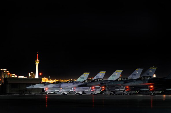 79th Fighter Squadron ‘Tigers’ pilots sit stacked on the Nellis AFB runway ramp with a view of the Las Vegas, Nev., skyline before taking off on their night missions during day one of Red Flag 13-3, Feb. 25, 2013. The ‘Tigers’ launched a total of 16 times during day and nighttime missions to kick off the exercise. The unit has approximately 15 F-16 Fighting Falcons on the ground at Nellis AFB and 35 pilots slated to fly throughout the three-week long exercise. (U.S. Air Force photo by Staff Sgt. Kenny Holston/Released)