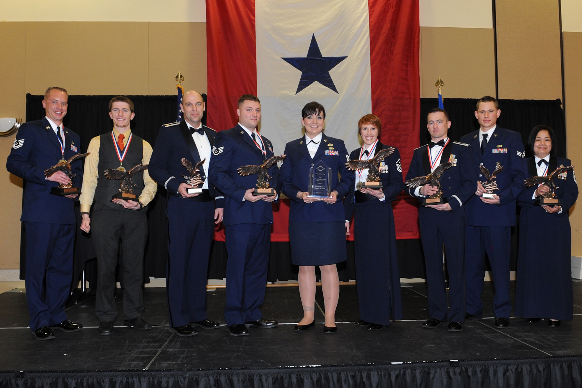 The evening's award winners take the stage at the 419th Fighter Wing's annual awards banquet at the Davis Conference Center in Layton Saturday: (left to right) Tech. Sgt. Brice Hollender, Mr. Cooper Remkes, Capt. Ty Campbell, Senior Airman Frederick Danneman, Tech. Sgt. Amanda Siaosi, Master Sgt. Jenny Nicholson, Capt. John Young, Senior Airman Errol Flynn, Senior Master Sgt. Marites Ramoneda-Thomas. (U.S. Air Force photo Alex Lloyd)