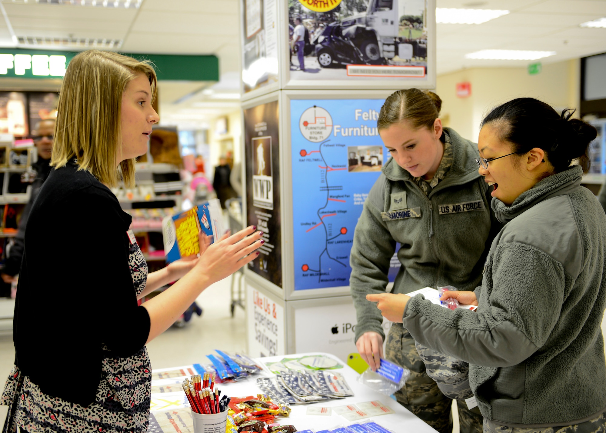 ROYAL AIR FORCE LAKENHEATH, England – Airman 1st Class Elisabeth Park (right)and Senior Airman Samantha Amorine, 48th Medical Surgical Squadron aerospace medical technicians, receive financial managment information from Charlotte Ashfold, Community Bank representative, during Military Saves Week Feb. 25, 2013. RAFL Airman and Family Readiness Center and Community Bank setup informational booths around base to encourage military families to start saving. (U.S. Air Force photo by Staff  Sgt. Stephanie Mancha)