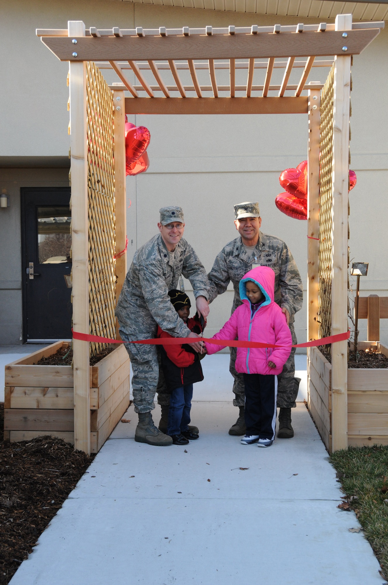 Lt. Col. Matthew Orlowsky (left), 436th Force Support Squadron commander, and Col.Thomas A. Reppart, 436th Mission Support Group commander, join Isaiah Devese, 4, and Kaleyah Croxsell, 4, two children enrolled at the Dover Air Force Base, Del., Child Development Center, in cutting the ribbon Feb. 15, 2013, for the CDC's new and improved playground for preschoolers enrolled at the center. The ribbon cutting ceremony served as the official opening of the playground, which features a new dramatic play stage and nature landscape area. (U.S. Air Force photo/Master Sgt. Veronica Aceveda)