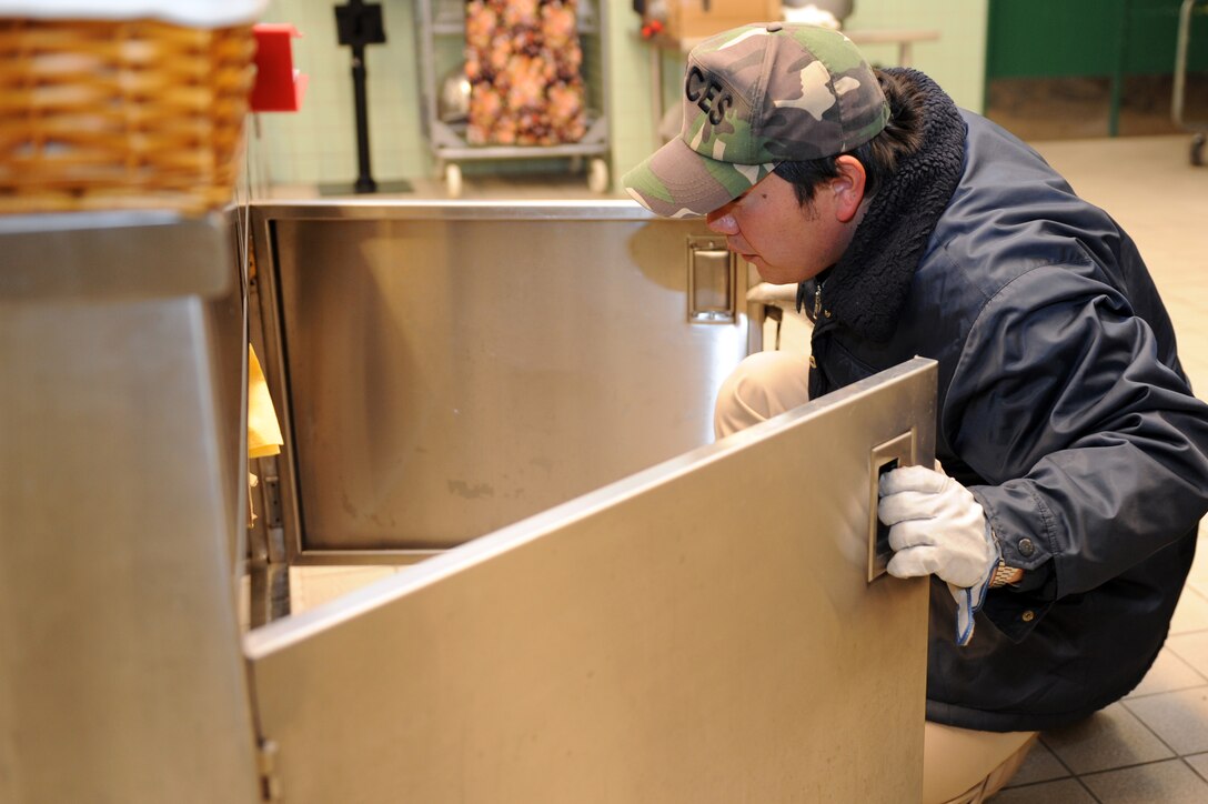 Mitsunori Takahashi, 35th Civil Engineer Squadron pest control, inspects a cupboard during a food facility inspection at Misawa Air Base, Japan, Feb. 25, 2013. Food facility inspections are done to ensure facilities are, and will remain, pest free. (U.S. Air Force photo by Airman 1st Class Kia Atkins)