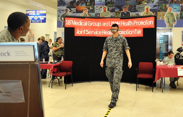 Japan Air Self-Defense Force Staff Sgt. Osamu Ogura tries on vision impairment goggles at the Exchange during a Joint Health Promotion Fair on Kadena Air Base, Japan, Feb. 21, 2013. The goggles allowed the audience to experience vision while in a drunken state and came in ranges from normal up to 0.25-percent blood alcohol content levels.  (U.S. Air Force photo/Naoto Anazawa)

