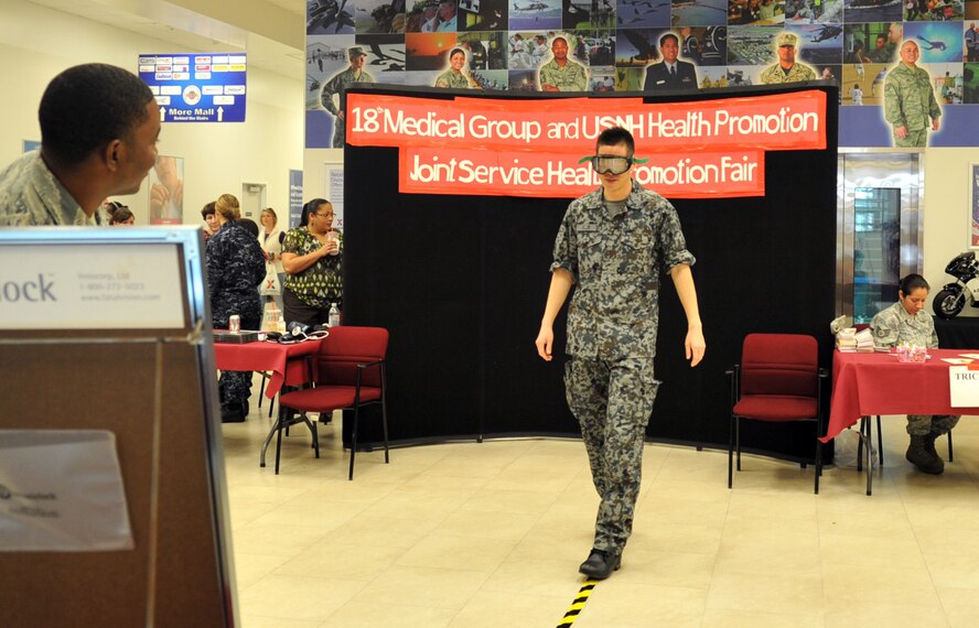Japan Air Self-Defense Force Staff Sgt. Osamu Ogura tries on vision impairment goggles at the Exchange during a Joint Health Promotion Fair on Kadena Air Base, Japan, Feb. 21, 2013. The goggles allowed the audience to experience vision while in a drunken state and came in ranges from normal up to 0.25-percent blood alcohol content levels.  (U.S. Air Force photo/Naoto Anazawa)

