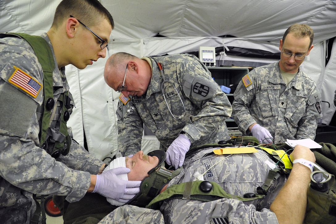 Army Pfc. Zachary Ross, left, and Army Col. Kenneth Locke, center ...