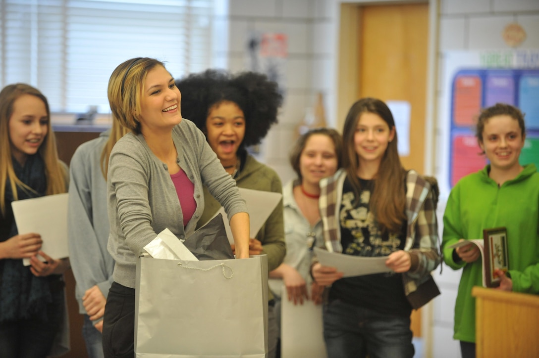 Crystal Gill, head coach, Quantico Middle School girls’ basketball team, anxiously opens her gift that was given by her team during the end-of-the-year Winter Awards ceremony at the school on Feb. 25. The team gave Gill a basketball with all of their signatures on it. 