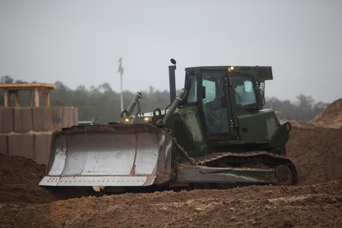 A bulldozer belonging to Engineer Company, Combat Logistics Battalion 6, 2nd Marine Logistics Group idles briefly before it demolishes the company’s forward operating base in the final stages of a training exercise aboard Camp Lejeune, N.C., Feb. 26, 2013. Combat engineers, heavy equipment operators and bulk fuel specialists worked together to set up, work in and dismantle a patrol base during the field operation in preparation for a future deployment.  