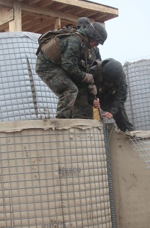 Marines with Engineer Company, Combat Logistics Battalion 6, 2nd Marine Logistics Group pull apart the wire mesh of a dirt-filled barrier during a 10-day training operation aboard Camp Lejeune, N.C., Feb. 26, 2013. The pre-deployment field operation was the first time the company built and worked with a forward operating base as part of a training exercise.  