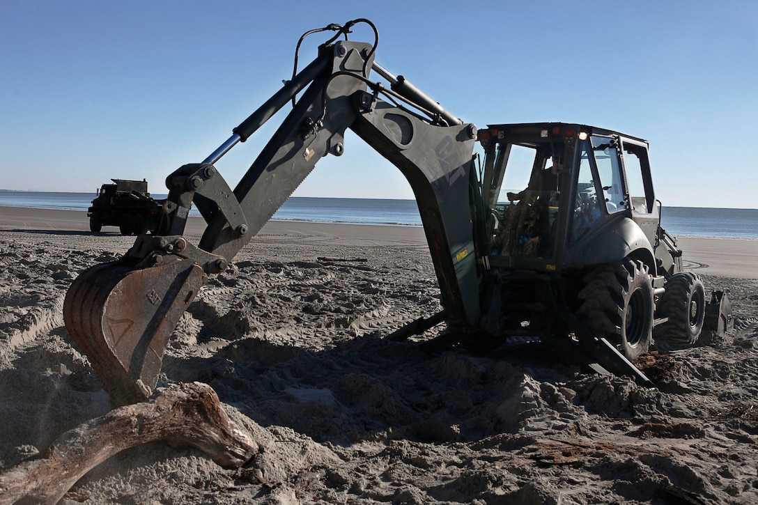 Lance Cpl. Avery Reddish, Marine Wing Support Squadron 273 heavy equipment operator, removes a tree during an Engineer Company Community Relations Project on Hunting Island State Park, Feb. 20. Hunting Island is currently the fastest eroding beaches on the East Coast losing approximately 15 feet of sand each year. 