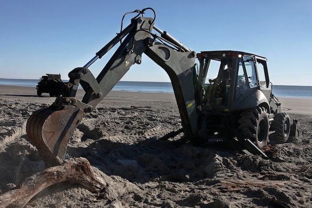 Lance Cpl. Avery Reddish, Marine Wing Support Squadron 273 heavy equipment operator, removes a tree during an Engineer Company Community Relations Project on Hunting Island State Park, Feb. 20. Hunting Island is currently the fastest eroding beaches on the East Coast losing approximately 15 feet of sand each year. 