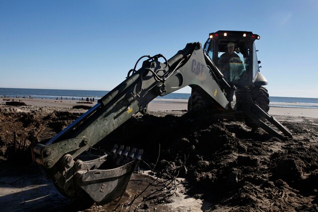 Lance Cpl. Lawrence Hulst, Marine Wing Support Squadron 273 heavy equipment operator, utilizes a backhoe loader to remove remains of a water closet on Hunting Island, Feb. 20. The engineer company is removing natural and man-made debris on the island’s north and south beach.  