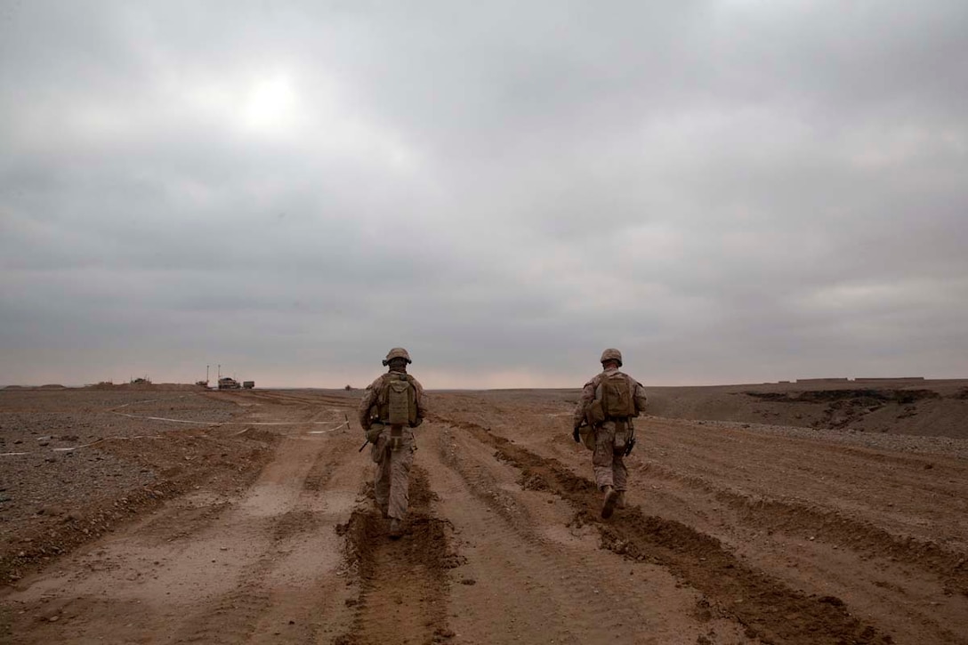 U.S. Marine Corps Lt. Col. Brian Neil, right, the executive officer of Regimental Combat Team (RCT) 7 and Gunnery Sgt. Mark F. Erhardt, the staff noncommissioned officer in charge of Ripper Mobile Assault Platoon, Headquarters Company, RCT-7, walk in a lane cleared by combat engineers while surveying battle positions during Operation Dynamic Partnership in Shurakay, Helmand province, Afghanistan, Feb. 15, 2013. Dynamic Partnership was a multi-unit operation to retrograde all U.S. military equipment and personnel from village stability platform Shurakay. (U.S. Marine Corps photo by Cpl. Alejandro Pena/Released)