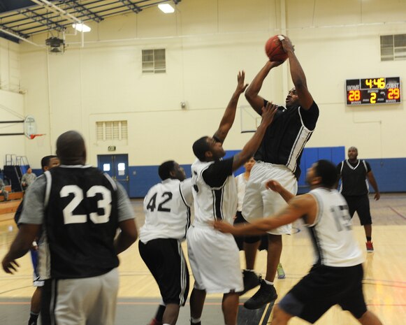 Master Sgt. Derrick, 48th Intelligence Squadron, elevates above the defense for a shot in the second half of the Intramural Basketball Championship at the Harris Fitness Center on Beale Air Force Base, Calif., Feb. 22. The 9th Aircraft Maintenance Squadron defeated the 48th IS 37-34. (U.S. Air Force photo by Airman 1st Class Bobby Cummings/Released)