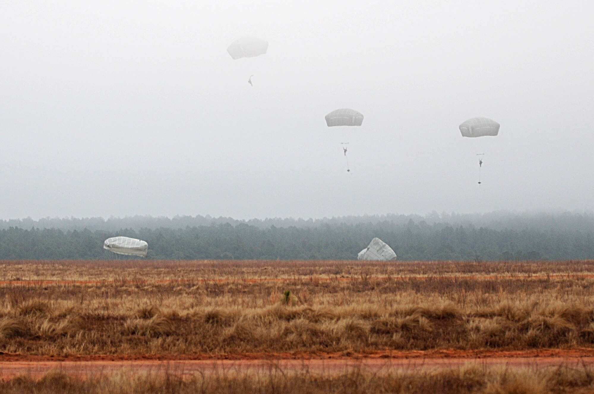 The silhouettes of paratroopers break through the cloud ceiling during an airborne operation, Feb. 23. Airmen assigned to 820th RED HORSE Squadron from Nellis Air Force Base, Nev., traveled to Fort Bragg, N.C., to conduct the airborne operation and airfield maintenance training with 161st Engineer Company, 27th Eng. Battalion, 20th Eng. Brigade. Both units will be augmenting 2nd Brigade Combat Team, 82nd Airborne Division for the Joint Operational Access Exercise, Feb. 27-March 9, as well as supporting 2BCTs Global Response Force mission. (U.S. Army photo by Sgt. Kissta DiGregorio)