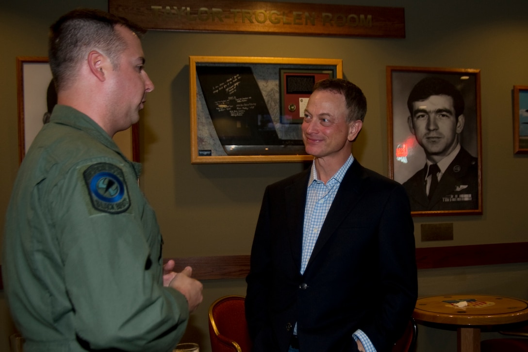 U.S. Air Force Tech. Sgt. Christofer Curtis, a CV-22 flight engineer of the 8th Special Operations Squadron, talks with Gary Sinise at the Hooch Bar and Grille at Hurlburt Field, Fla., Feb. 8, 2013. Curtis had previously met Sinise in the hospital while Curtis recovered from injuries sustained during a deployment. (U.S. Air Force photo by Airman 1st Class Naomi M. Griego)