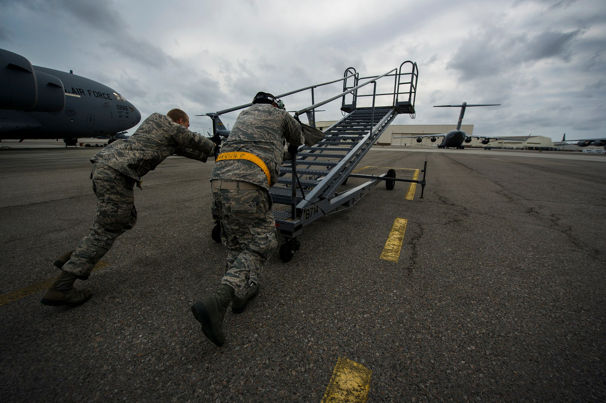 Airman 1st Class Minh Pham and Airman Cory Parks, 437th Aircraft Maintenance Squadron crew chiefs, move a B-1 Stand into position during a post flight inspection Feb. 26, 2013, at Joint Base Charleston - Air Base, S.C. Members of the 437th AMXS inspect, service and maintain C-17A aircraft to enable them to perform assigned global airlift missions ranging from combat support operations and humanitarian relief to aeromedical evacuations. (U.S. Air Force photo/ Senior Airman George Goslin)