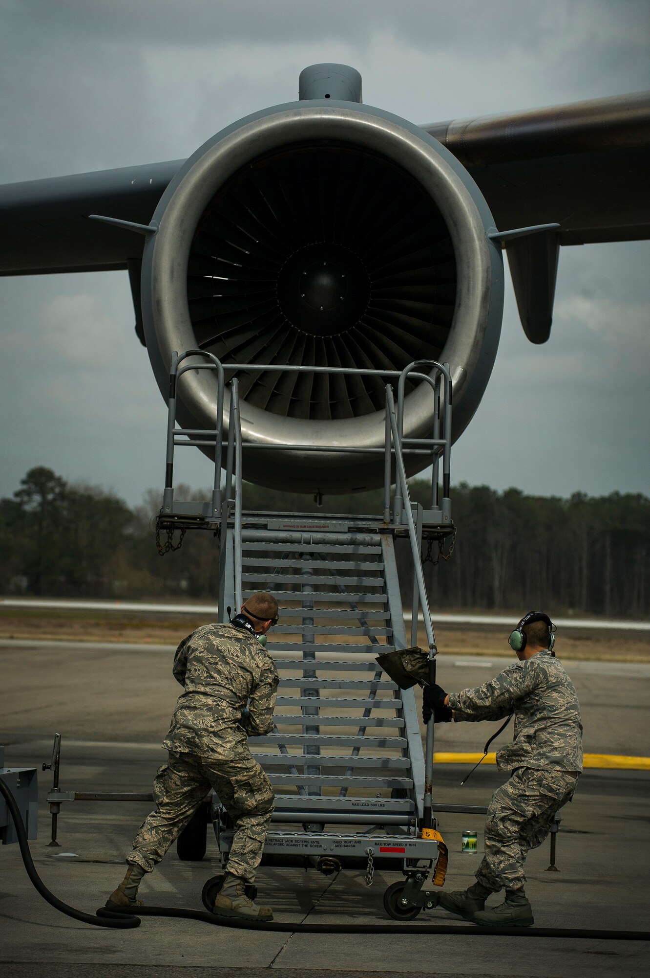 Airman 1st Class Minh Pham and Airman Cory Parks, 437th Aircraft Maintenance Squadron crew chiefs, move a B-1 Stand into position during a post-flight inspection Feb. 26, 2013, at Joint Base Charleston - Air Base, S.C. Members of the 437th AMXS inspect, service and maintain C-17A aircraft to enable them to perform assigned global airlift missions ranging from combat support operations and humanitarian relief to aeromedical evacuations. (U.S. Air Force photo/ Senior Airman George Goslin)