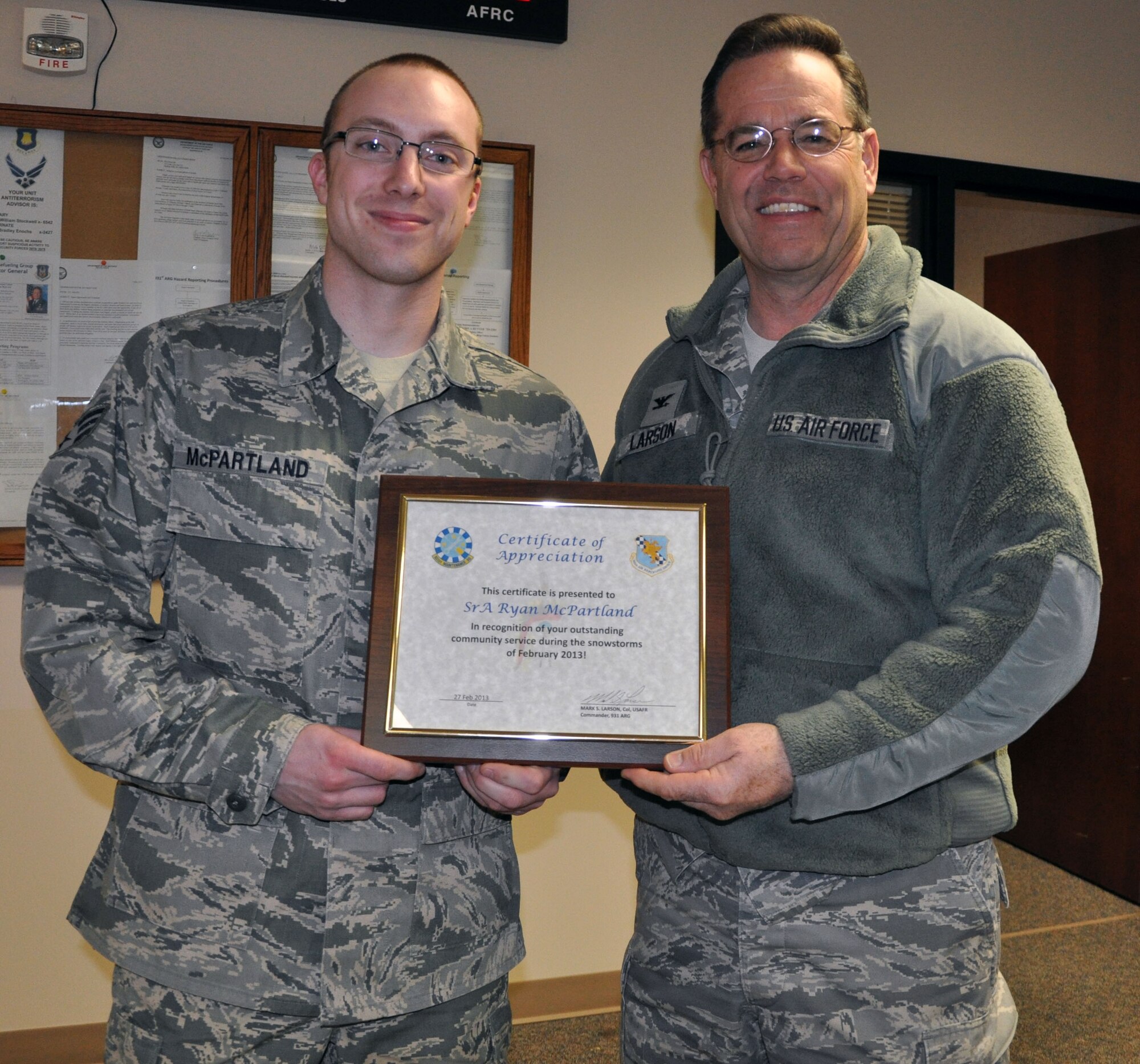 Col. Mark S. Larson, commander of the Air Force Reserve 931st Air Refueling Group, McConnell Air Force Base, Kan., presents a framed certificate of appreciation to Senior Airman Ryan McPartland, 931st Maintenance Squadron, prior to a Group staff meeting, Feb. 27, 2013.  Larson recognized McPartland for outstanding community service during severe snowstorms that had dumped more than 14 inches of snow on the area during the previous week.  McPartland had voluntarily shoveled the sidewalks of his apartment complex the day after the storm so that residents of the apartments could make their way to their vehicles.  (U.S. Air Force photo by 1st Lt. Zach Anderson)