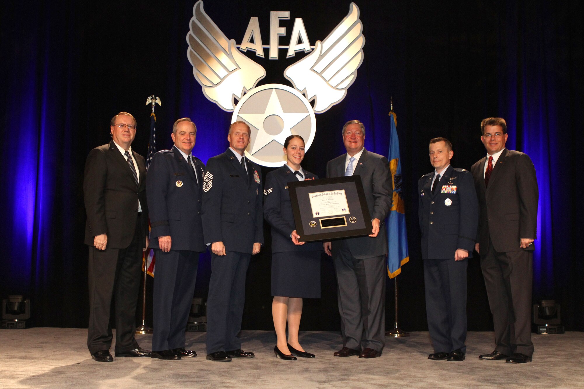 Accepting a diploma as the 400,000th Airman to receive a degree from the Community College of the Air Force is Senior Airman Emily Barchenger.  The Honorable Michael B. Donley, Secretary of the Air Force, presented the diploma and was joined by (R to L) AFA Central Florida Chapter President Michael Liquori, Community College of the Air Force Commandant Lt Col Jonathan T. Hamill, Chief Master Sergeant of the Air Force James A. Cody, Air Force Chief of Staff General Mark A. Welsh III, and Air Force Gala Chairman Tim Brock. (Courtesy photo)