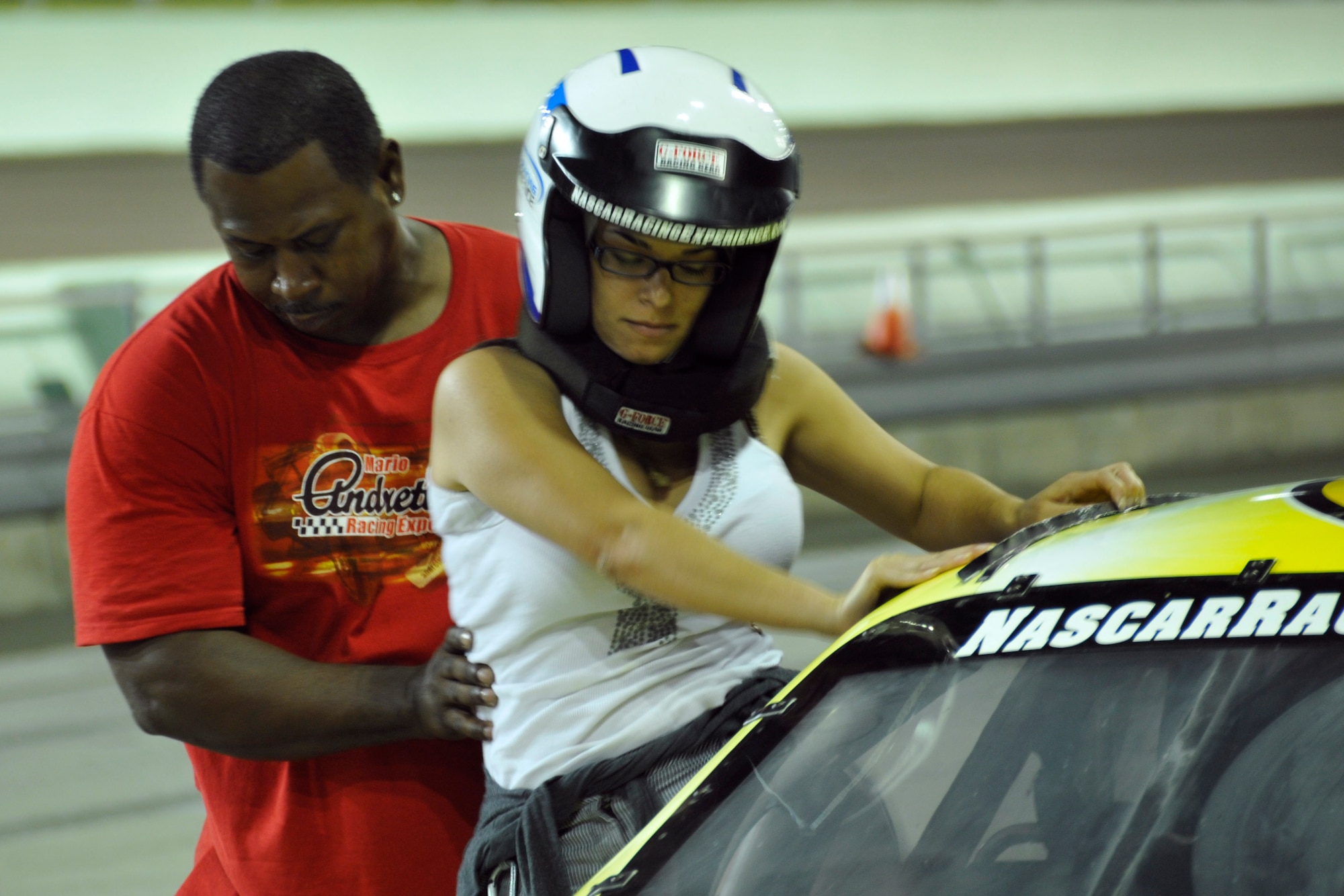 Sharon Navarro crams into the passenger seat of a NASCAR stock car at the Homestead-Miami Speedway Feb. 23. Airmen from Homestead Air Reserve Base, Fla., participated in the NASCAR Racing Experience in support of the Single Airman Initiative. During the event, Airmen took laps around the Speedway along with a professional racing instructor. The Single Airman Initiative is a program for all local servicemembers, regardless of rank, service, or marital status, to participate in several community events, to include airboat tours of the Florida Everglades and scuba diving classes, which are free of charge. (U.S. Air Force photo/Senior Airman Nicholas Caceres)