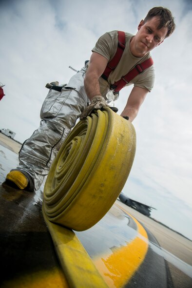 U.S. Air Force Staff Sgt. Jordan Gren, 23d Civil Engineer Squadron fire protection crew chief, rolls a fire hose during a phase I operational readiness exercise Feb. 25, 2013, at Moody Air Force Base, Ga. During the scenario, Green and his team extracted two pilots from a burning HC-130P Combat King. (U.S. Air Force photo by Staff Sgt. Jamal D. Sutter/Released)