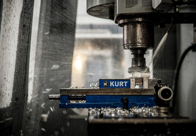 A computer operated mill shaves a thin layer of aluminum off a block of metal Feb. 26, 2013, at Joint Base Charleston – Air Base, S.C. Airman 1st Class Tashma Antoine, 437th Maintenance Squadron aircraft metals apprentice, operated the machine by using a hand held remote. Antoine is assigned to the aircraft metals fabrication shop and is trained to use several different pieces of equipment to bend, cut and combine metals. Antoine is originally from Fort Myers, Fla. (U.S. Air Force photo/ Senior Airman Dennis Sloan)