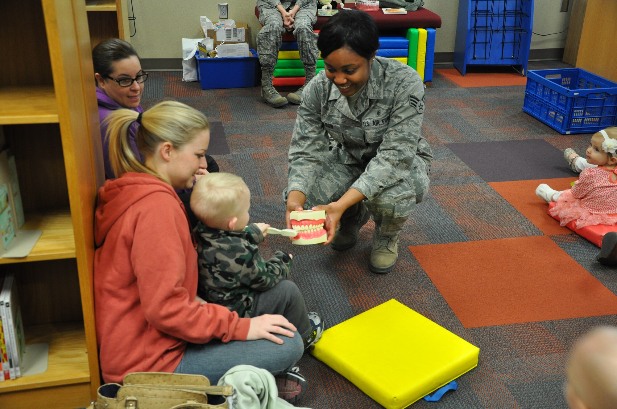 GOODFELLOW AIR FORCE BASE, Texas- Senior Airman Tiffany Wilson, 17th Medical Operations Squadron dental assistant, lets one of the children at the dental health presentation brush the teeth of a model mouth at the Consolidated Learning Center here, Feb. 27. In support of Children’s Dental Health month, the children were read stories about teeth and given packets containing toothbrushes, toothpaste and more. (U.S. Air Force photo/ Airman 1st Class Erica Rodriguez)