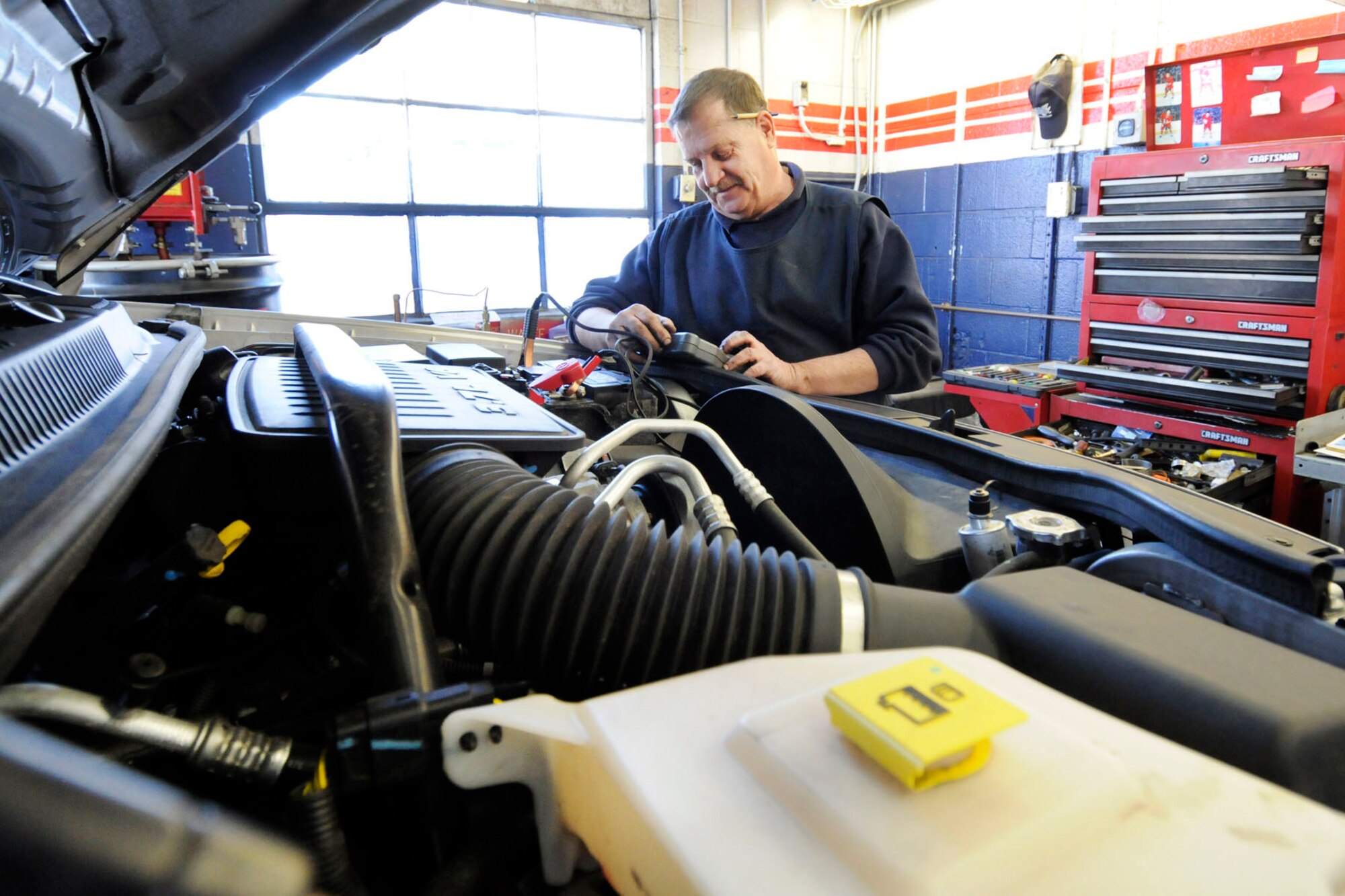 HANSCOM AIR FORCE BASE, Mass. -- John Hall, an Army and Air Force Exchange Service auto worker, checks a vehicle's battery that is in for service at the Car Care Center Feb. 22. Hall began his career in 1986 and has spent the past 27 years serving Hanscom servicemembers. (U.S. Air Force photo by Linda LaBonte Britt)