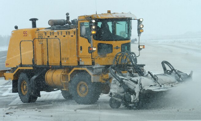 92nd Civil Engineer Squadron members clear snow from the runway using a vehicle known as a snow broom at Fairchild Air Force Base, Wash., Feb. 25, 2013. The snow-removal team is responsible for keeping the runway and taxiways clear of snow and ice during the winter season. (U.S. Air Force photo by Airman 1st Class Janelle Patiño)