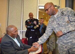 U.S. Army Command Sgt. Maj. J. Antez Gilbert, McDonald Army Health Center command sergeant major, presents a challenge coin to retired Master Sgt. Lee R. Griffin, a World War II veteran, on his 100th birthday celebration at Fort Eustis, Va., Feb. 22, 2013. Col. Michael E. Hershman, MCAHC commander, invited Griffin to the health center to celebrate the occasion and share his life's experiences with MCAHC personnel. Griffin retired from the Army after 31 years of service, and is one of few Soldiers alive today who served under famed leader Gen. George S. Patton, Jr. (U.S. Army photo by Marlon J. Martin/Released)
