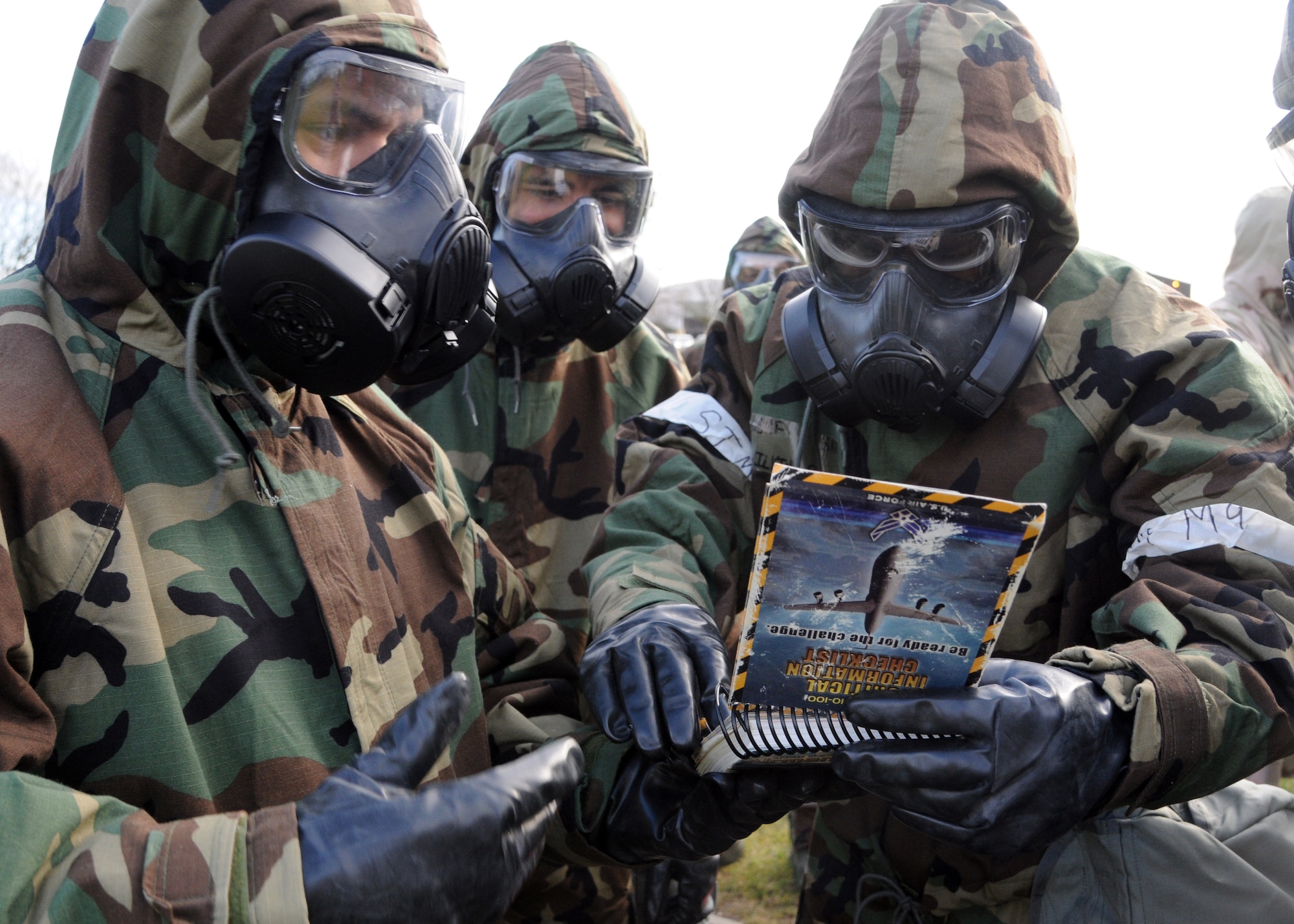 Airmen reference their Airman’s Manual during chemical, biological, radiological and nuclear training Feb. 7, 2013, in 680 at RAF Mildenhall, England. The Airmen, who were part of a post-attack reconnaissance team, were trying to identify a simulated unexploded ordnance. (U.S. Air Force photo by Airman 1st Class Kelsey Waters/Released)